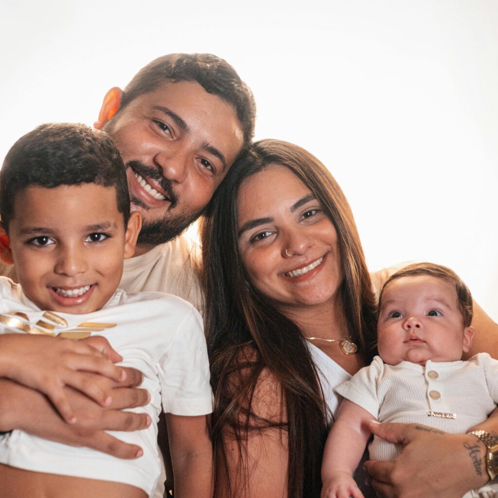 Joyful family portrait featuring smiling parents with their young children.