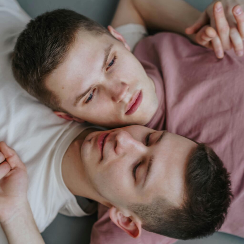 Close-up of a couple sharing a tender moment, lying together with expressions of peace and contentment.